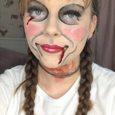 a student has painted her face as a creepy doll